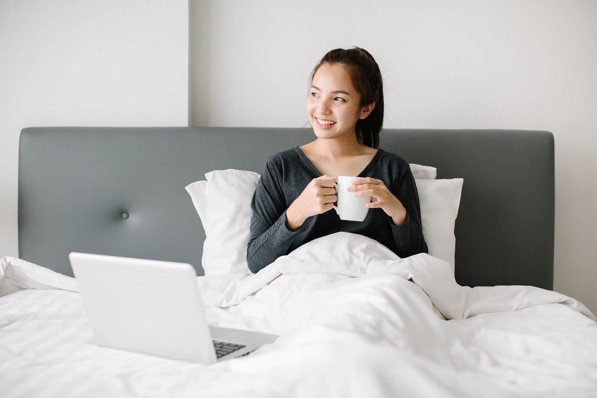 woman drinking something in bed