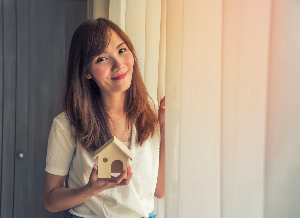 young woman holding a home miniature