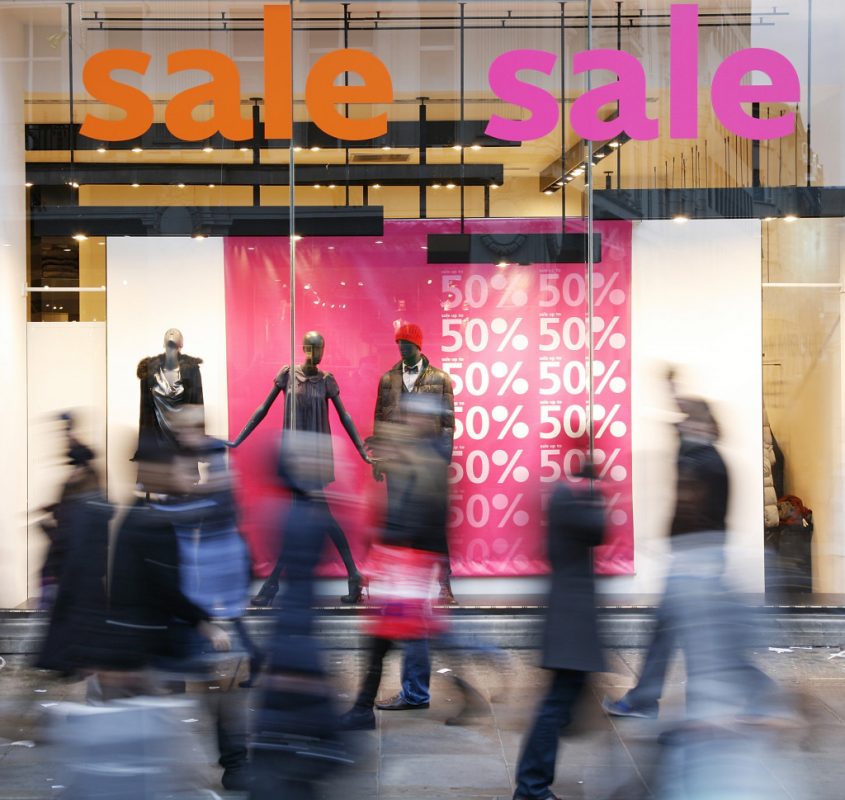 Retail store window showing discount signs 