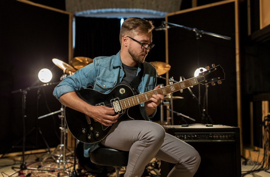 A person playing the guitar using instruments