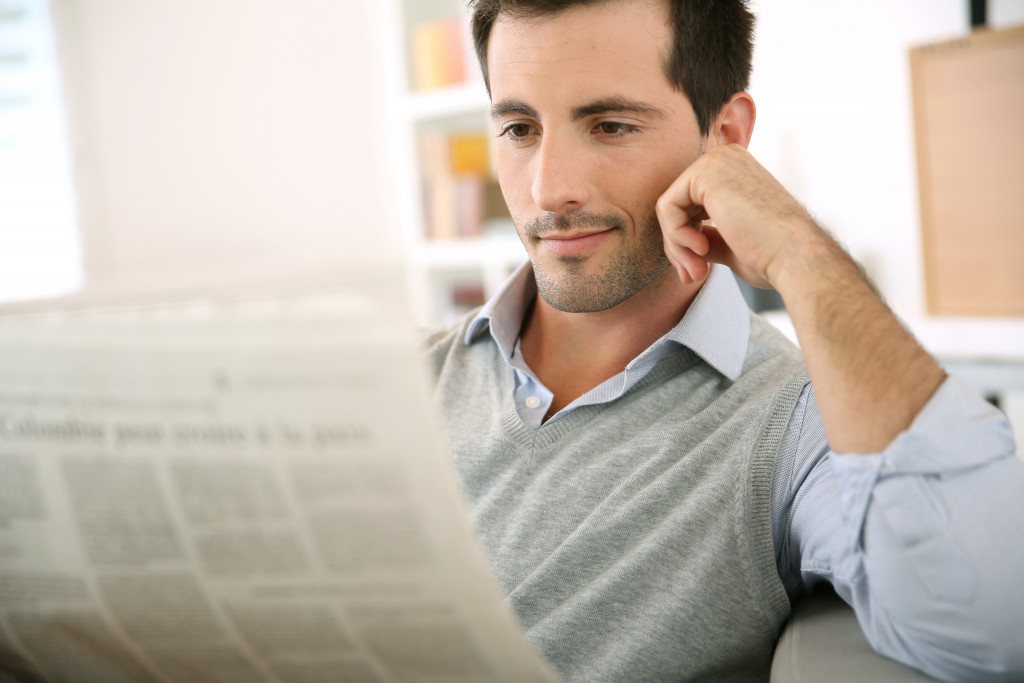 a businessman reading a newspaper to stay updated with latest trends