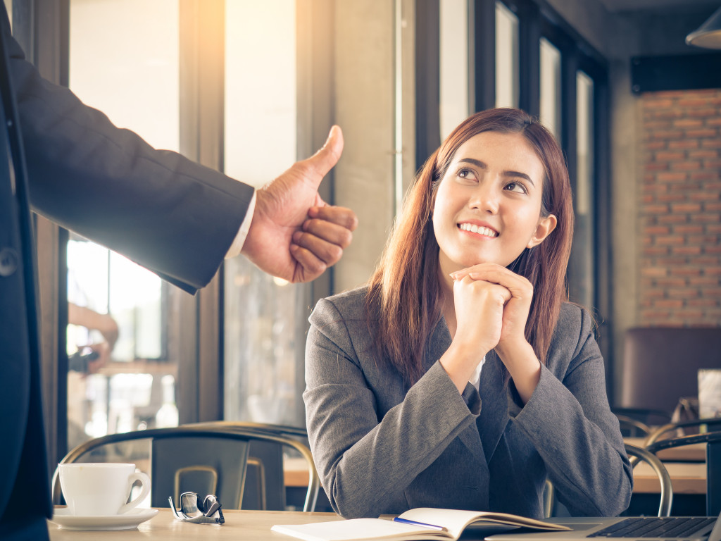 A manager showing their appreciation to an employee while she is working