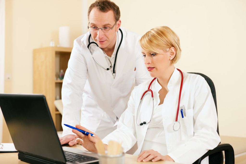 two doctors analyzing something on the laptop