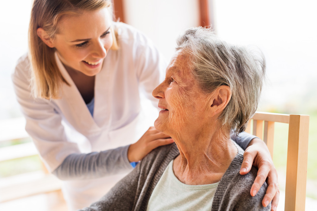 A healthcare worker communicating with an elderly woman