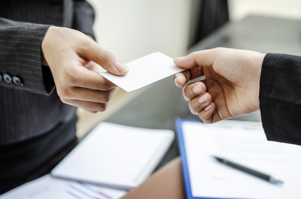 Business professionals exchanging business cards in an office