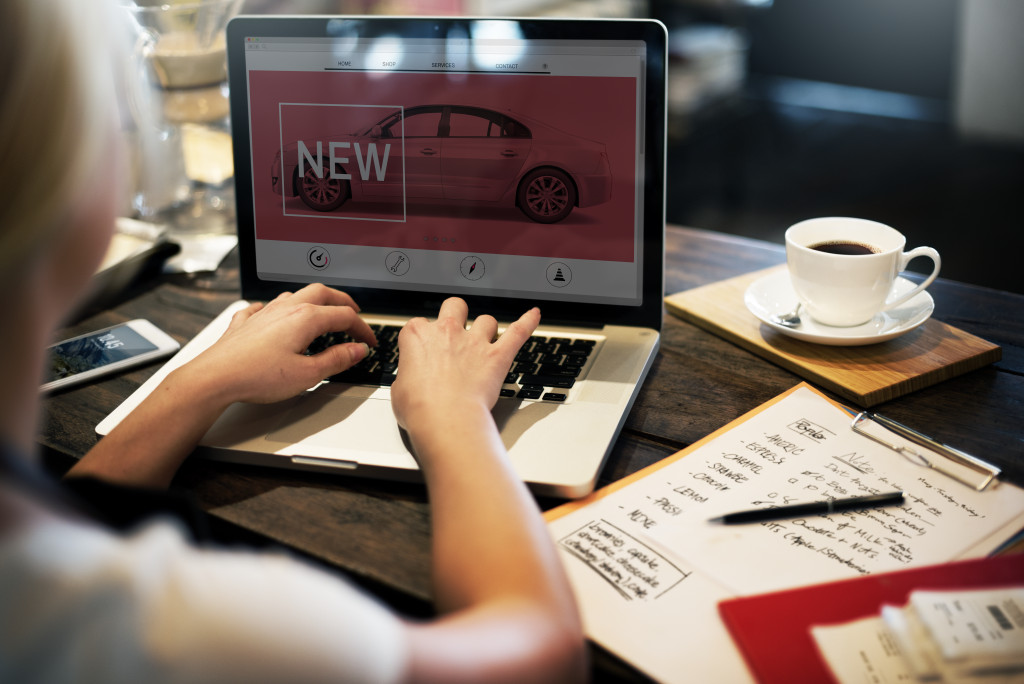 a young woman using a laptop to post on a website about new products