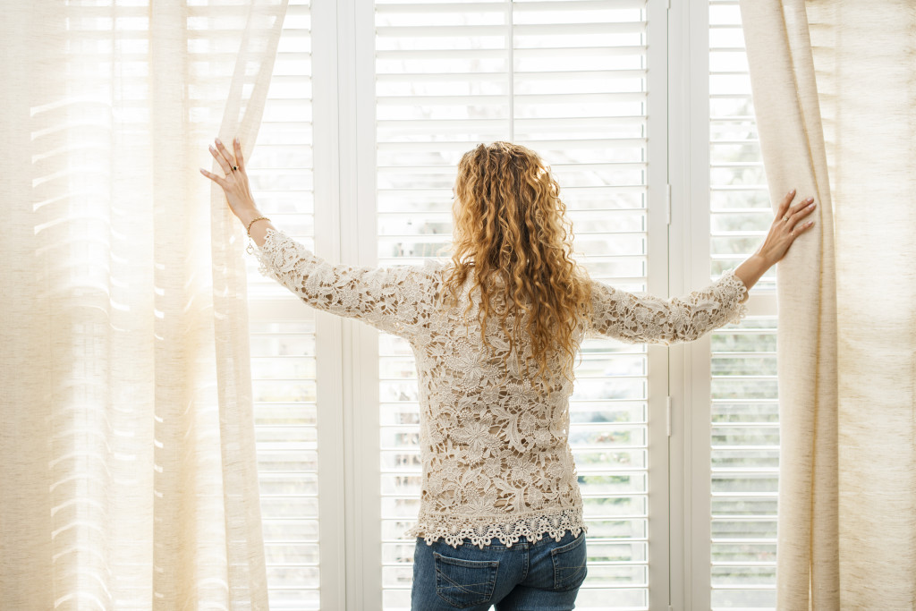 a woman looking out a modern and big window