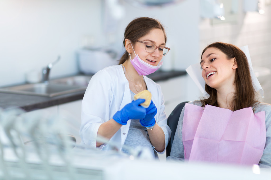 a woman smiling at the female dentist explaining the procedure to her