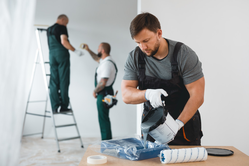 Efficient renovation crew painting white walls of new build home