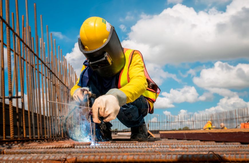 A worker welding metal at an under-construction building