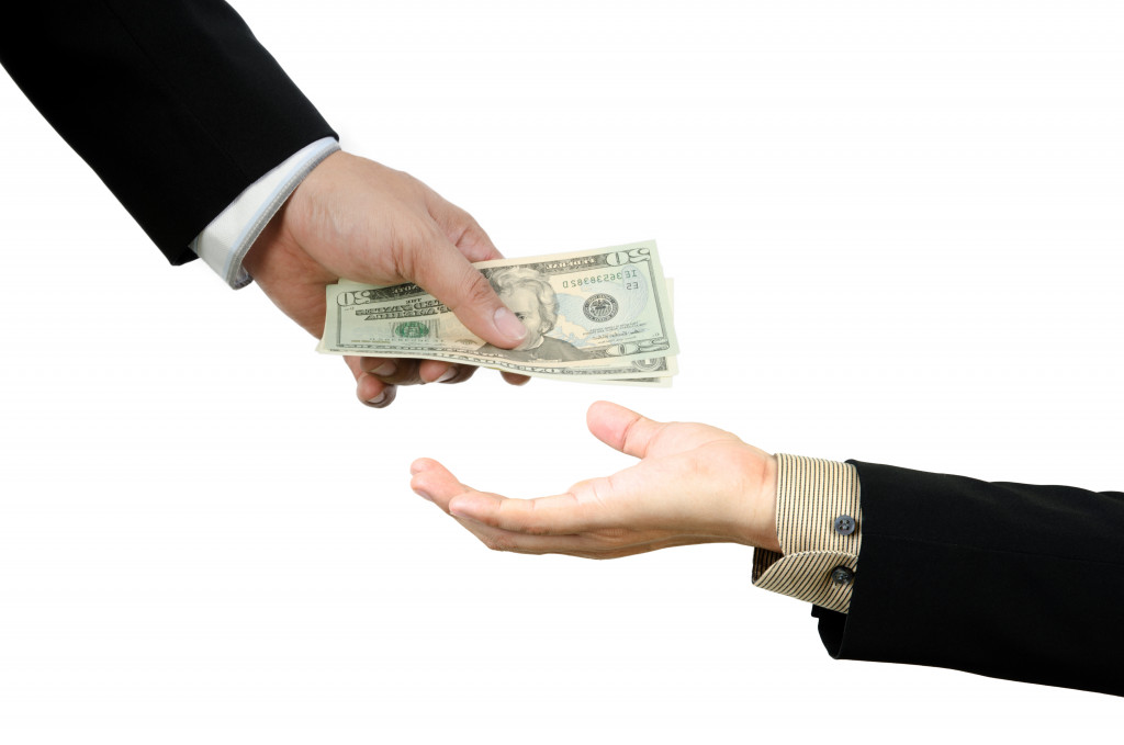 Concept of borrowing money. A hand giving money to another hand