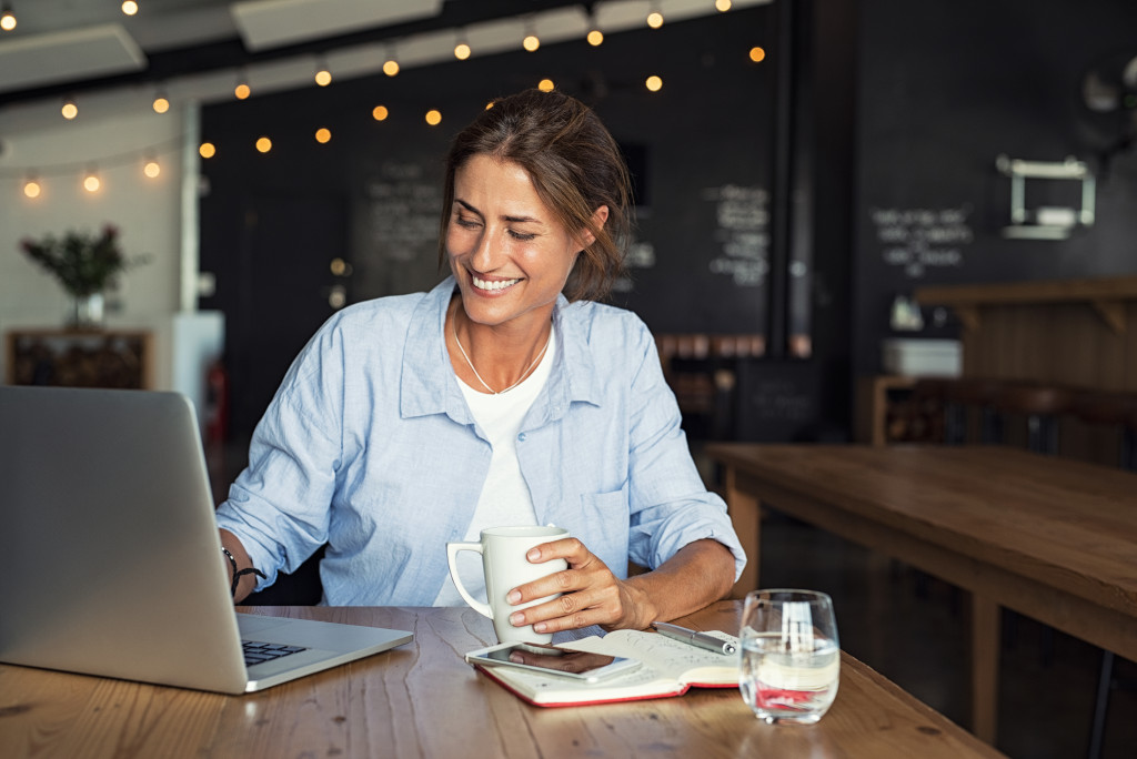 woman sitting in cafe working on laptop