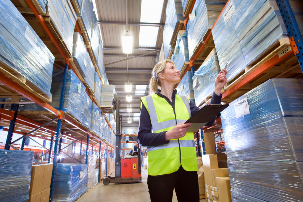 A woman checking inventory space in warehouse