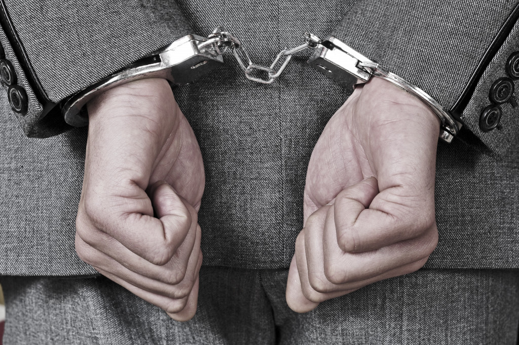 man wearing a suit with handcuffs