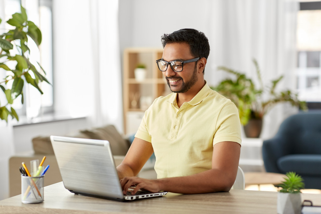 a smiling man on his laptop