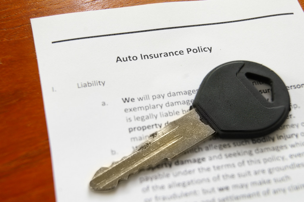 a car key on top of insurance policy