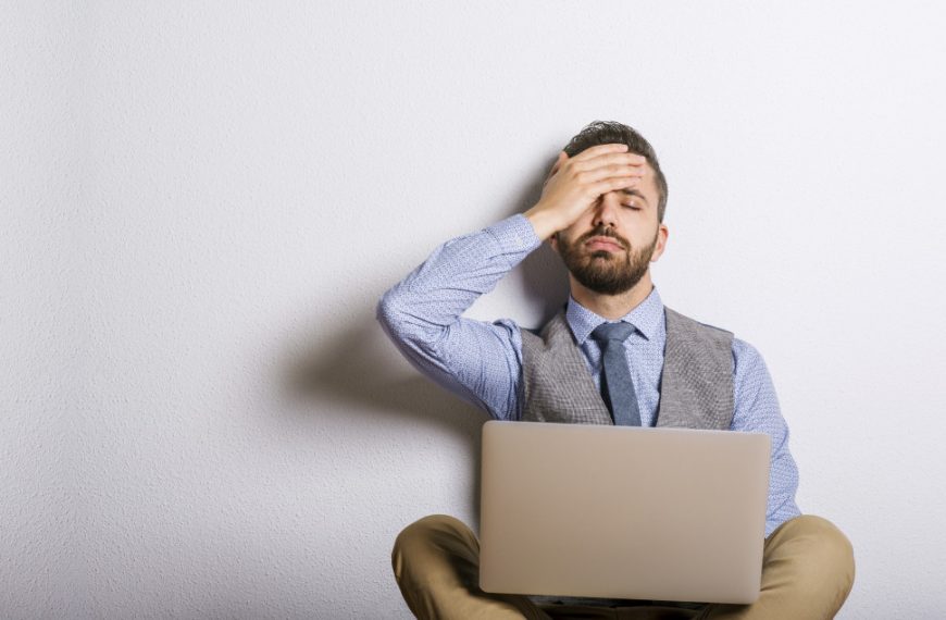 Stressed businessman sitting on floor