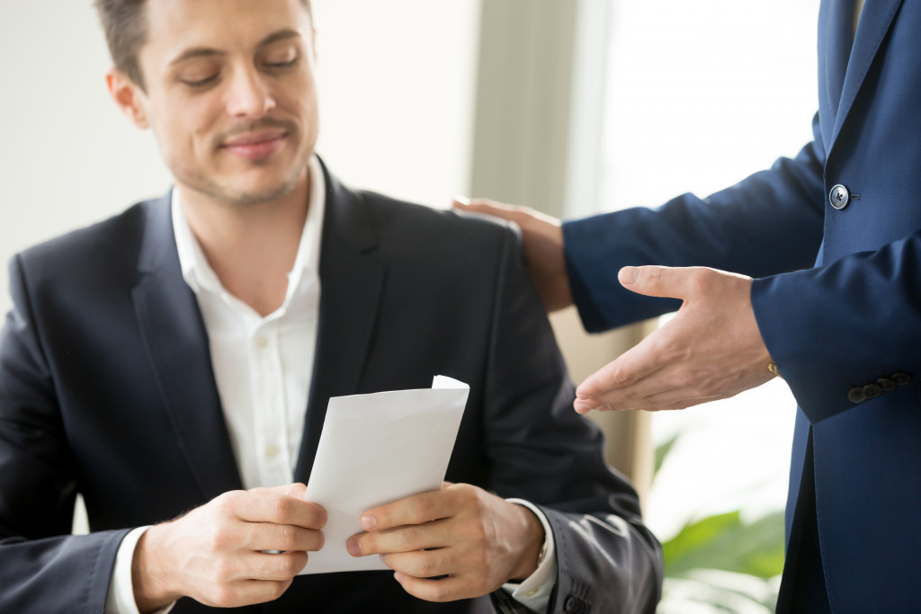 employee receiving cash in envelope