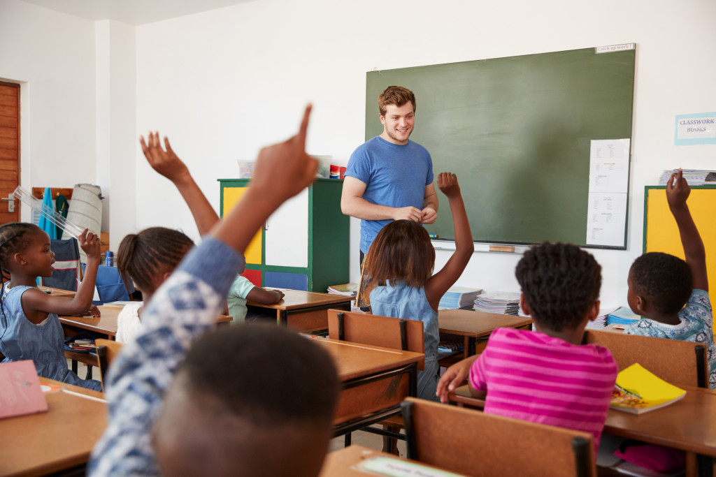 Children raising their hands in the classroom