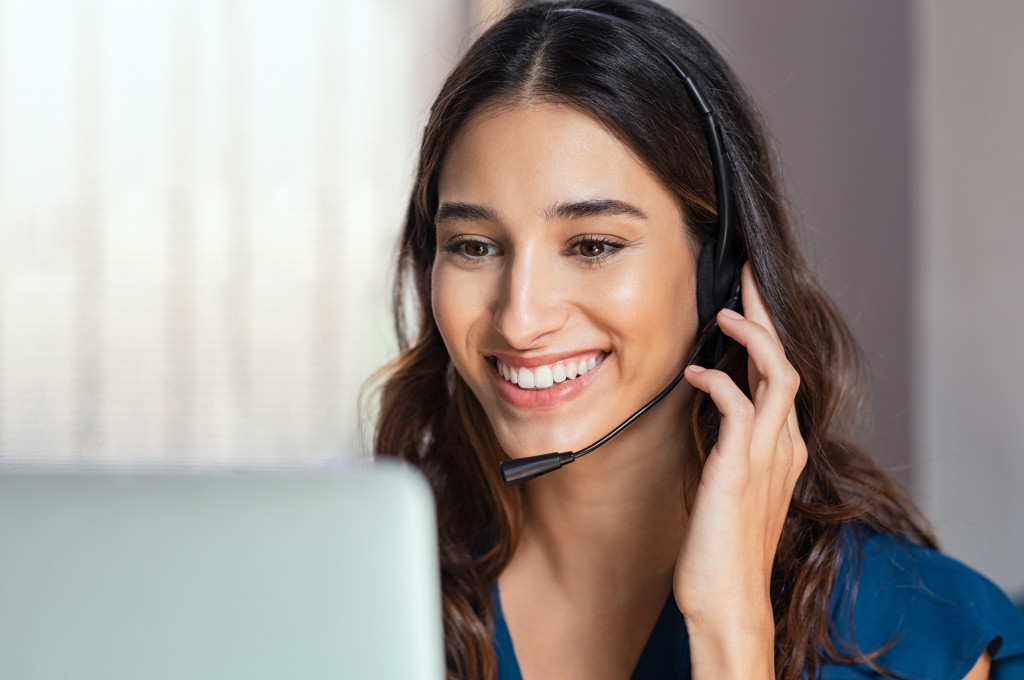 A woman talking to a client with headphones