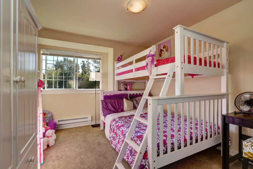 a female bedroom with a bunk bed and pink bedding